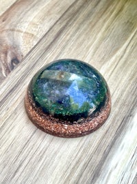 a blue and green stone on top of a wooden table