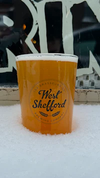 a cup of beer sitting in the snow