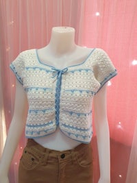 a mannequin wearing a blue and white crocheted top