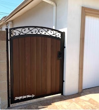a wooden gate with an ornamental design in front of a house