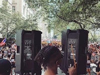a man with dreadlocks is standing in front of a crowd of people