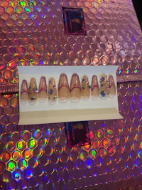 a box of fake nails sitting on top of a pink background