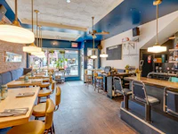 the interior of a restaurant with wooden tables and chairs