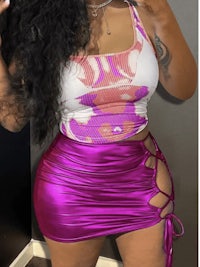 a black woman in a purple top and skirt