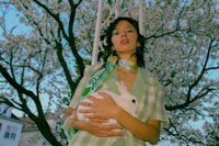 a woman in a green dress holding a white bunny