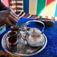 a man is pouring tea on a tray