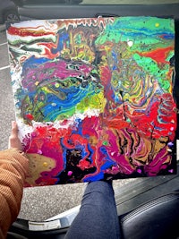 a person holding a painting in a car
