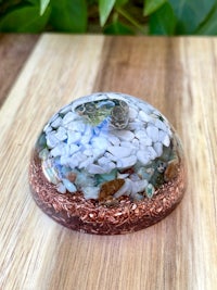 a glass sphere filled with rocks and pebbles on top of a wooden table