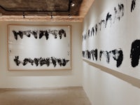 a room with black and white paintings hanging on the wall