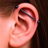 a woman's ear with a blue piercing