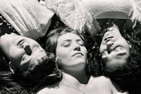 a black and white photo of three women laying down