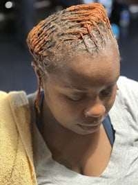 a woman with dreadlocks sitting in a salon