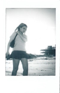 polaroid of a woman walking on the beach
