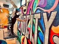 a man painting a mural on a wall