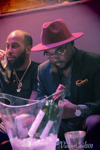 two men sitting next to each other at a party