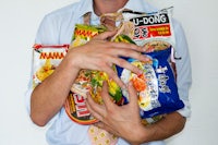 a man holding a bag of ramen noodles