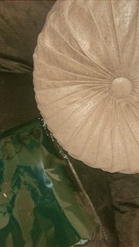 a white pillow on a couch next to a bag