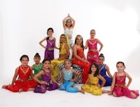 a group of girls in colorful costumes posing for a photo