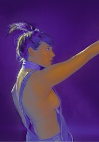 a woman in overalls is pointing at something in a purple background