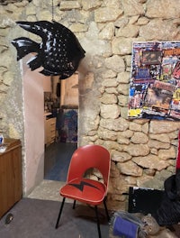 a room with a red chair and a fish hanging from the ceiling