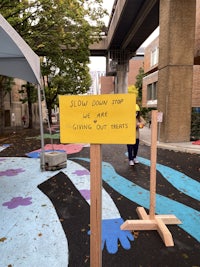 a yellow sign on a sidewalk