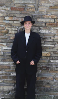 a woman wearing a black suit and hat
