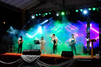 a group of people performing on stage at an outdoor event