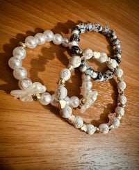 three bracelets with pearls on a wooden table