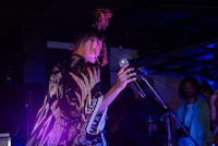a woman in a kimono singing into a microphone