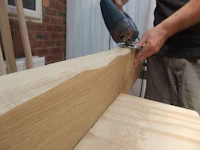 a man using a saw to cut a piece of wood