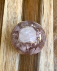 a pink quartz ball on top of a wooden table