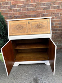 a white and wood bureau with a door open