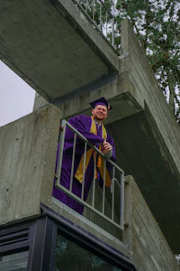 a man in a purple robe standing on a balcony