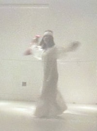 a woman in a white dress is dancing in a room