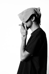 a black and white photo of a man smoking a cigarette