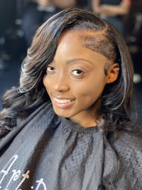 a black woman with long curly hair in a salon