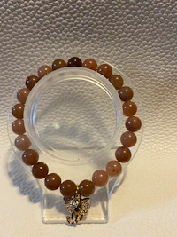 a bracelet with brown beads and a gold plated clasp