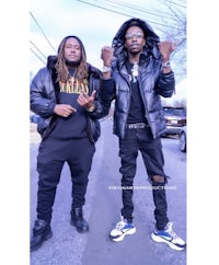 two men in black jackets standing next to each other