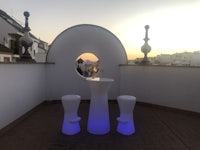 a table and two stools on a rooftop
