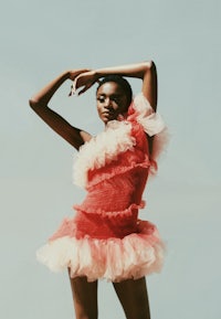 a black woman in a red tulle dress posing