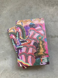 a set of colorful notebooks on a concrete floor