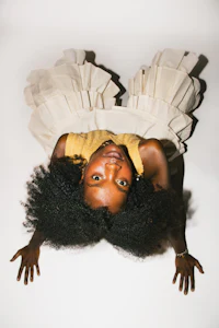 a black woman in a white dress laying on her stomach