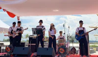 a group of people playing music on stage in front of a tent