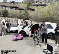 a group of people standing next to a white car