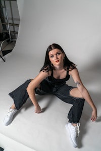 a woman posing in front of a white background