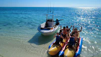 a group of people on inflatable rafts near a boat