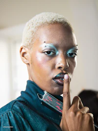 a woman is holding a finger to her lips