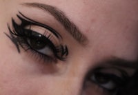 a close up of a woman's eye with black eyeliner