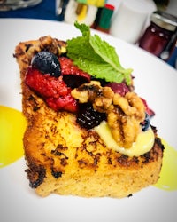 a plate of french toast with berries and nuts