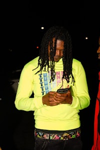 a man with dreadlocks looking at his cell phone